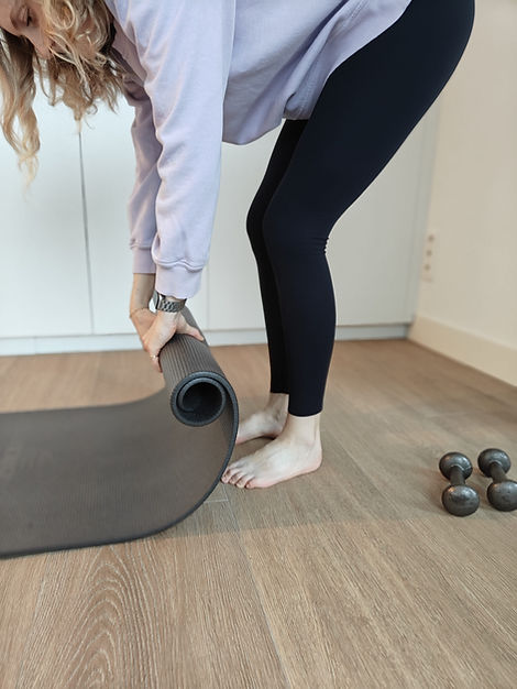 Vrouw rolt yogamatje op na stretchen