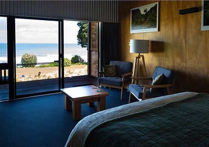 Nikau room bed and sitting area with views to tasman sea_edited.jpg