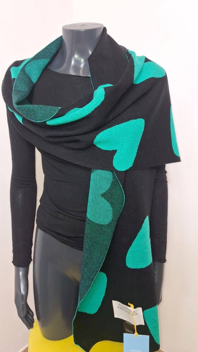 Manichino con sciarpa nera e verde a forma di cuore, in negozio.