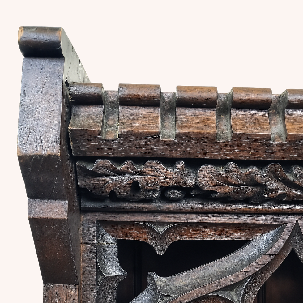 Victorian Gothic oak bookcase with carved tracery, leaf frieze and castellated top.