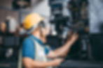 Industrial technician working in a modern factory helps to communicate the production machine. Employees operate the heavy machinery plant