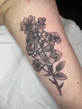 Stippled dotwork tattoo of a birthflower arrangement