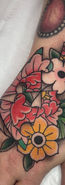traditional colour hand tattoo of a heart shaped peony jigsaw with flowers