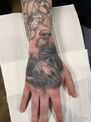 Black and grey neo traditional hand tattoo of a ram skull