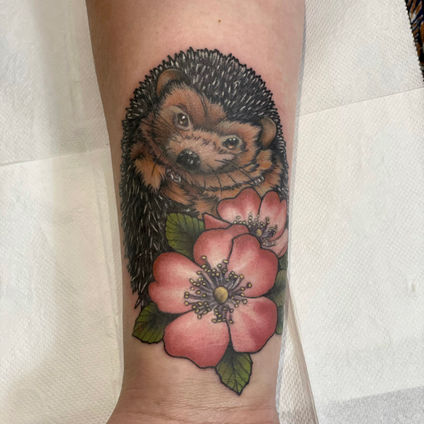 Colour neo traditional tattoo of a hedgehog with dog roses