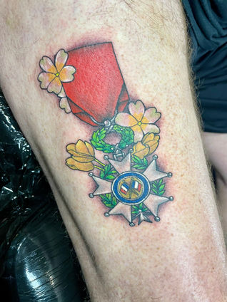 Colour neo traditional tattoo of a medal