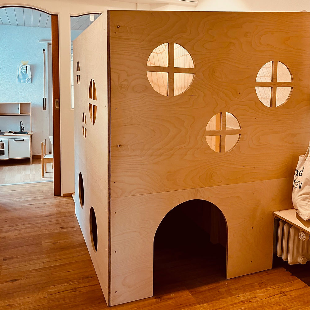Ein liebevoll gefertigtes, hölzernes Spielhaus mit zwei Stöcken, das die Kita-Kinder für das freie Spiel nutzen können.