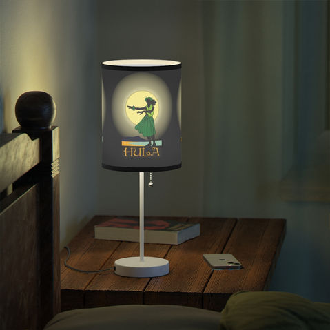 Night stand with a illuminated lamp depicting a hula girl silhouetted by the moonlight.