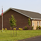 Building with flags in front, Hall Rentals, green grass and trees, Harrison TWP.