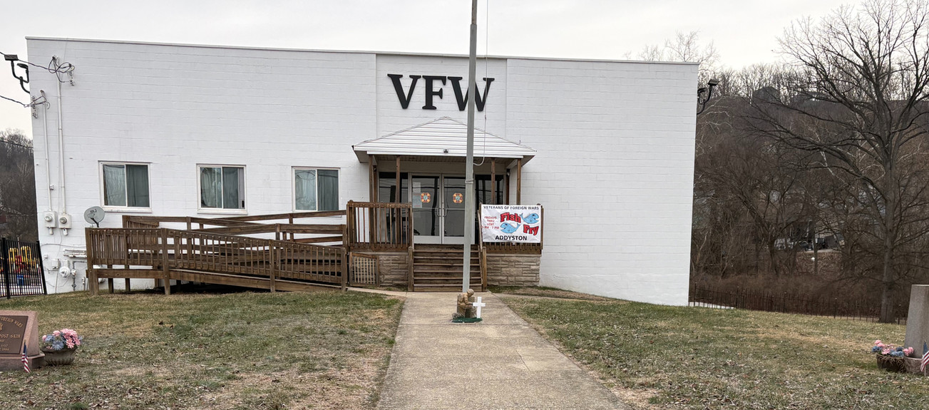 VFW building with ramp, flagpole, and ground memorials
