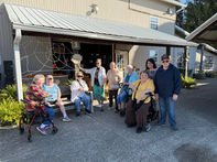 Group of seniors smiling outside a building, Senior Center, happy people, together.