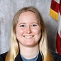 Smiling woman in Tri-State Rescue uniform with flags.