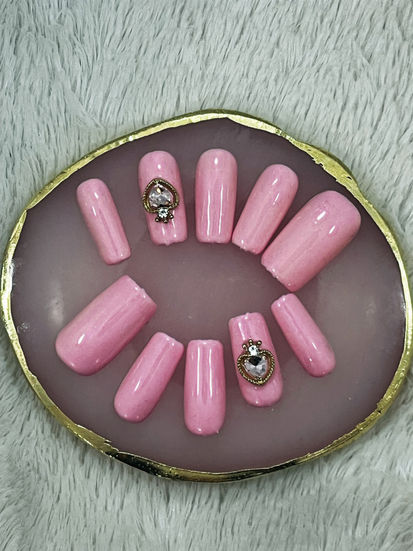 Glossy pink press-on nails with heart crystal charms