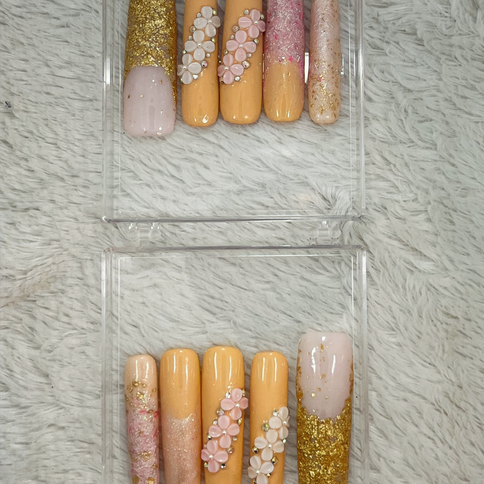 Press-on nails with peach, pink, and gold glitter, floral designs