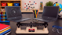 Cracked and undamaged school laptops on a scale representing repair vs. replacement.