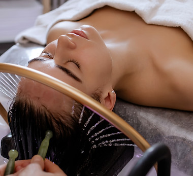 Close-up of a woman receiving a relaxing Japanese head spa treatment, with green massage s