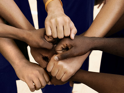 Team Putting Fists Together In Huddle