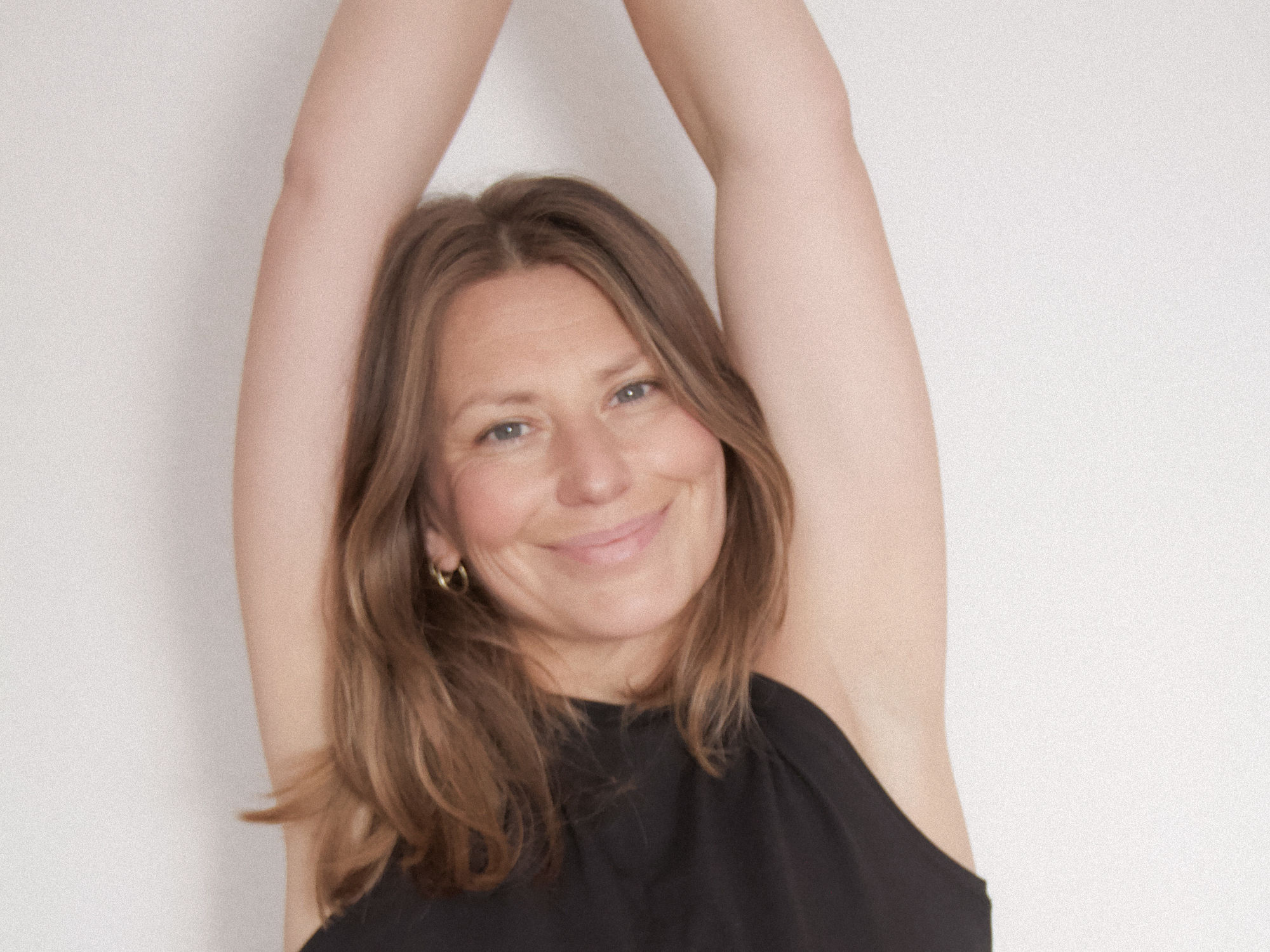 Julia Brugger Yoga beim ganzen Rad vor weißem Hintergrund auf schwarzer Matte
