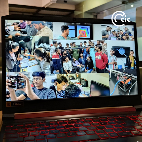 CIC students and mentors exploring CubeSat satellite models with antennas and space electronics PCBs