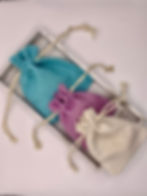 Fabric pouches of various colours, blue, purple and off white.