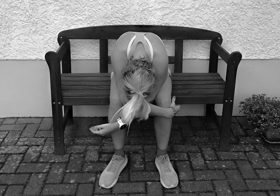 Nele sitzt erschöpft nach dem Laufen auf einer Bank