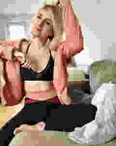 Nele sitzt auf der Couch und trägt eine Sweatshirt-Jacke und eine Tight von Mandala