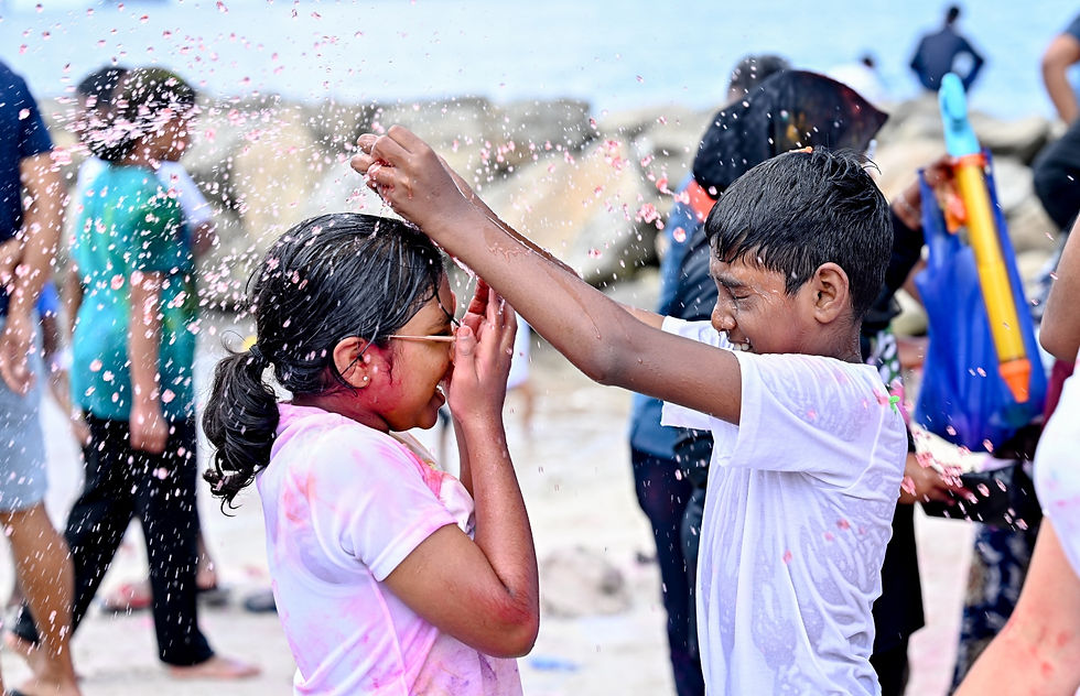 Miniatura: Boy puts pink powder on girl's head at holiday