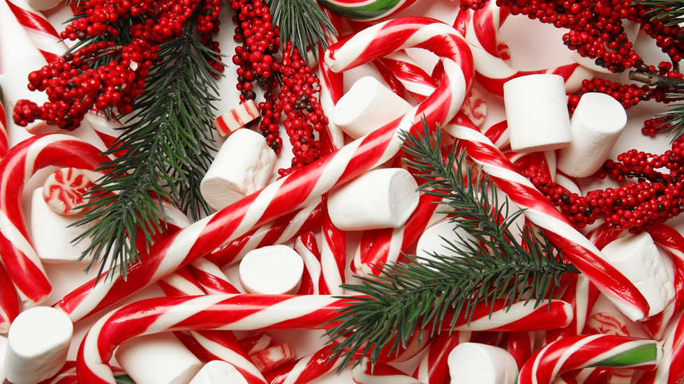 Белые и красные рождественские конфеты в праздничной композиции