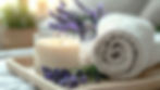 A lit white candle and a rolled towel on a wooden tray with sprigs of lavender. Soft focus background, conveying a calm, relaxing mood.