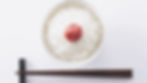 japanese rice with umeboshi on top. chopsticks aside of rice dish