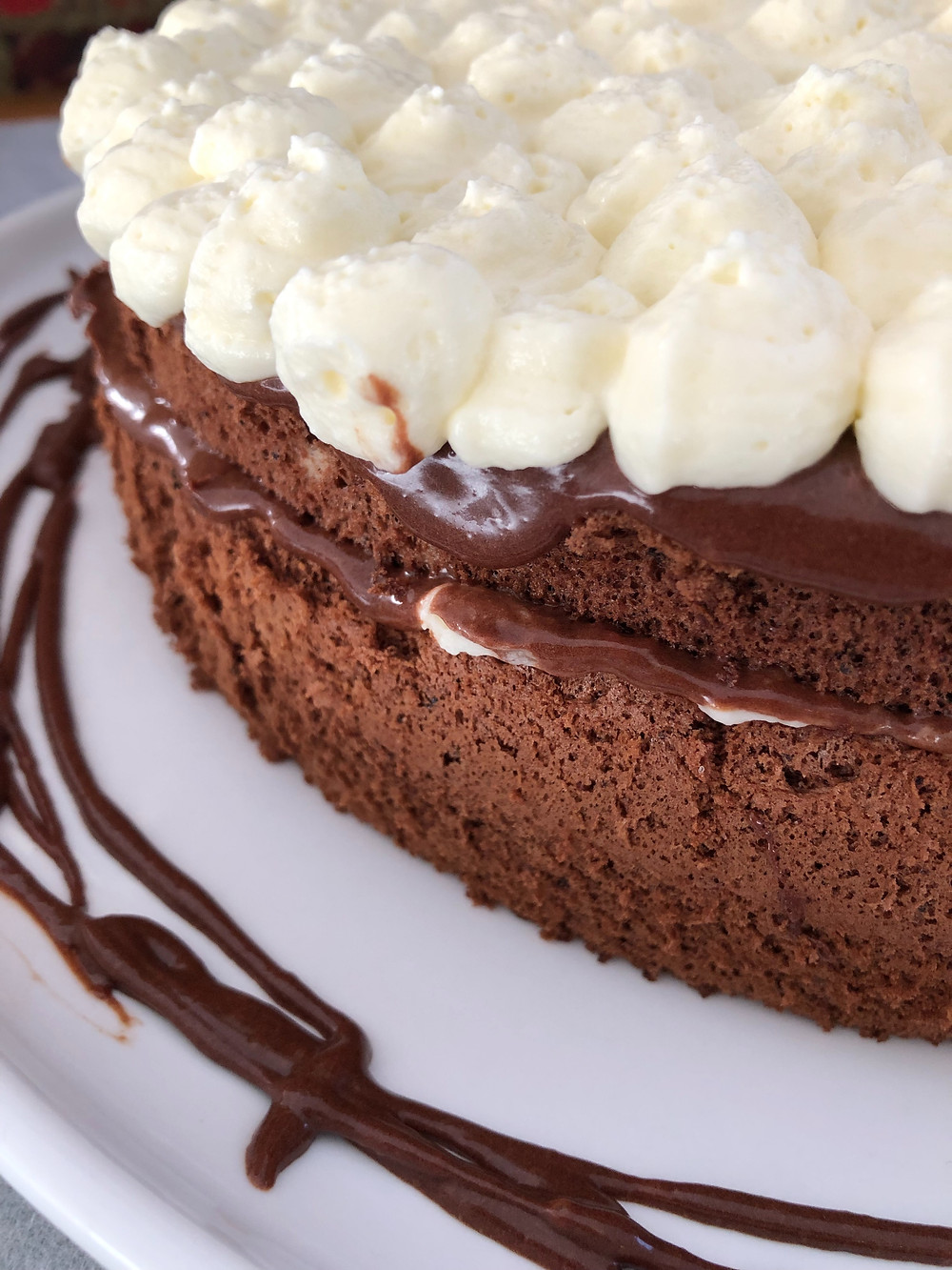 Close up of the cake, showing chocolate ganache layer and vanilla cream layer on top