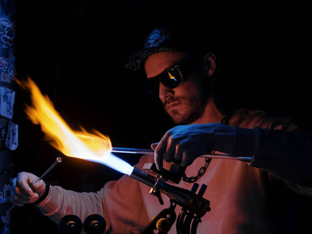 man making glass with fire