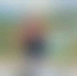 A woman holding glass of champagne and plate of pasta on the balcony of the villa