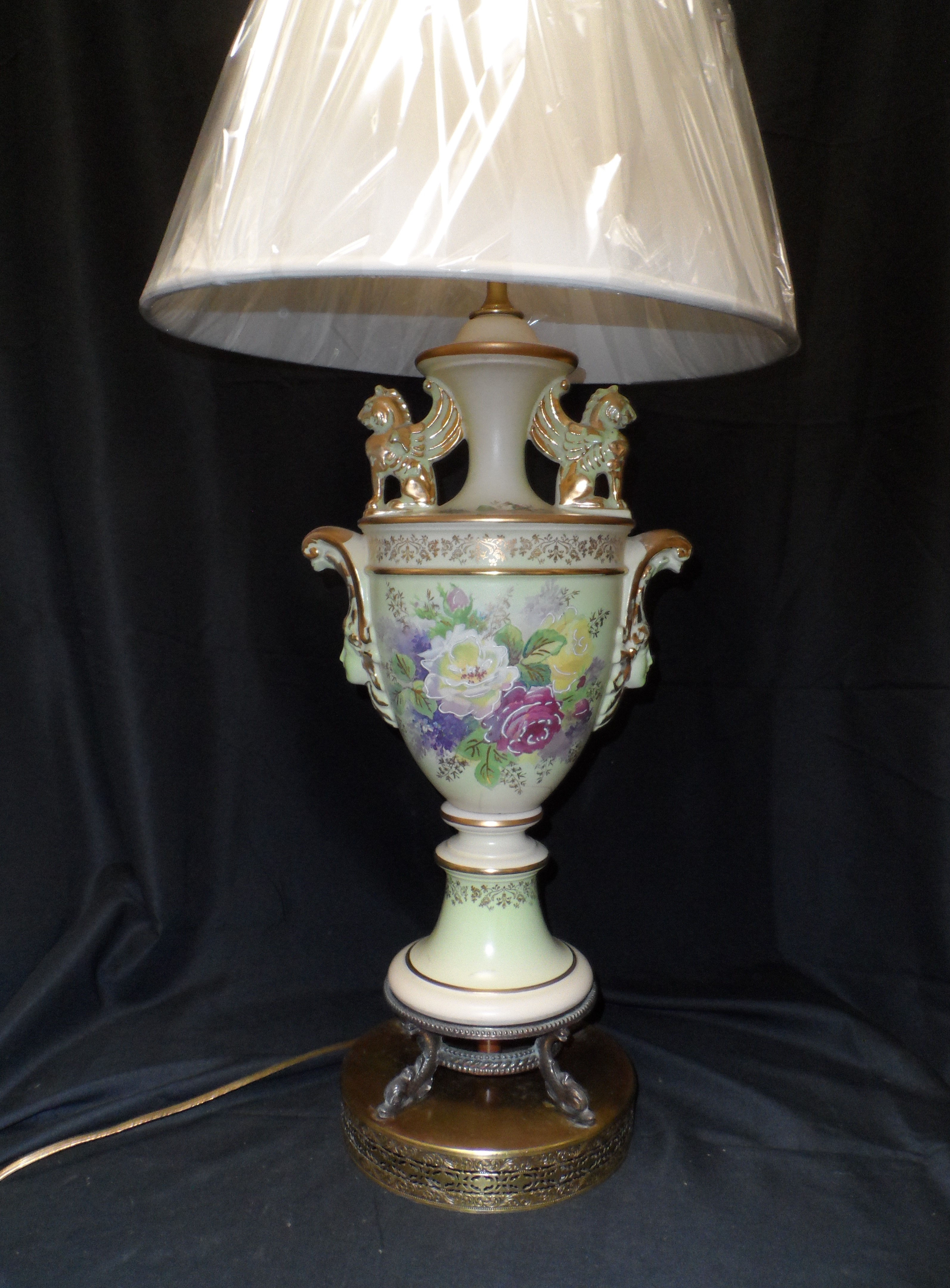 Pair of antique hand-painted ceramic urn table laps with floral motifs.