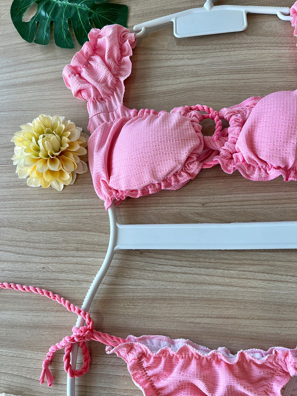 Thumbnail: Rosa Bandeau bikini with short sleeves and tie-side bikini bottom in a vibrant floral pattern, displayed on a flat surface.