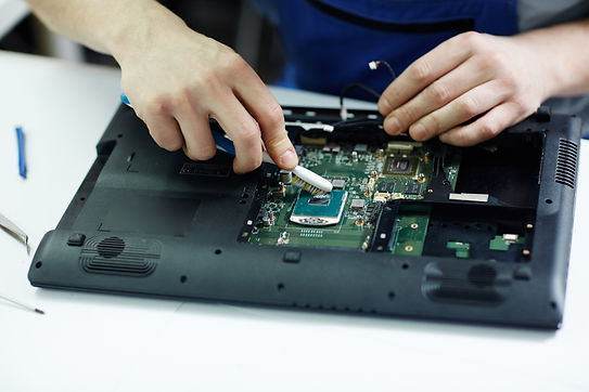 technician-clearing-circuit-board-disassembled-laptop.jpg