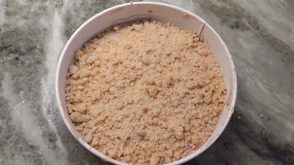 Unbaked blueberry crumb cake in round pan topped with almond crumble — step-by-step coffee cake recipe with yogurt and blueberries, ready to bake