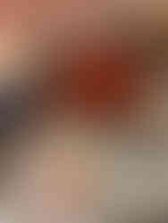 Homemade matcha cake topped with strawberries and a sweet cream drizzle being spooned over the top.