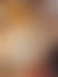 Person decorating a cake with chocolate frosting art and red jam details, featuring a face design and the words “Team Edward.