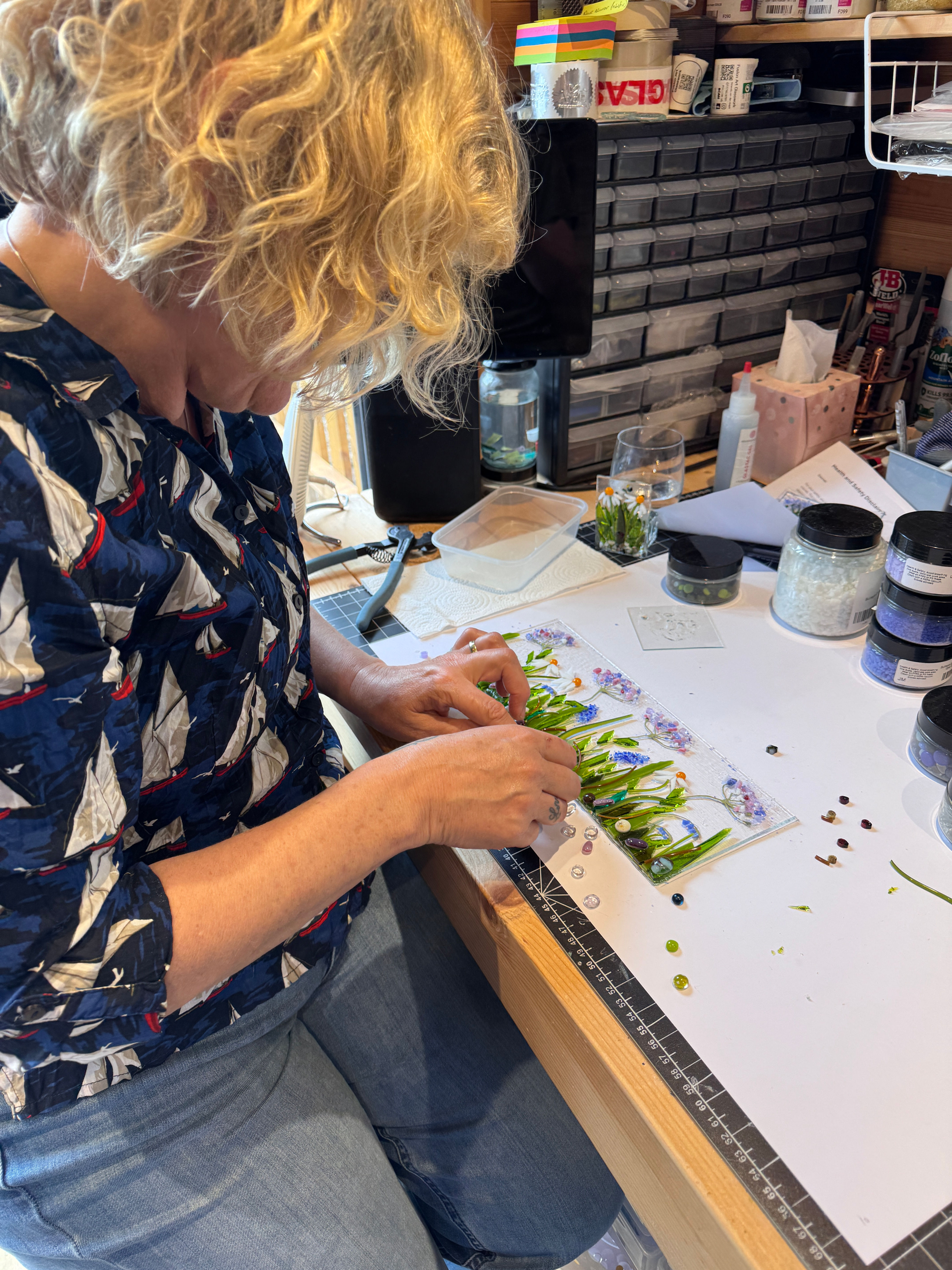 Student creating a fused glass floral scene
