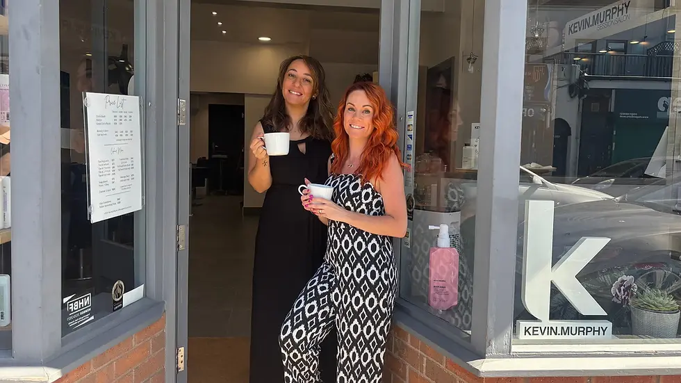 Two women at Cats Whiskers Hair Salon enjoying coffee