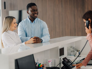 Healthcare front desk staff verifying patient insurance and registration details to prevent claim denials and improve revenue cycle performance