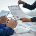 Business owner reviewing bookkeeping reports, cash flow statements, and financial records to identify gaps that impact business growth