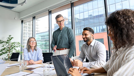 Business team collaborating in a modern office conference room with laptops and documents — highlighting corporate strategy, teamwork, and professional decision-making.