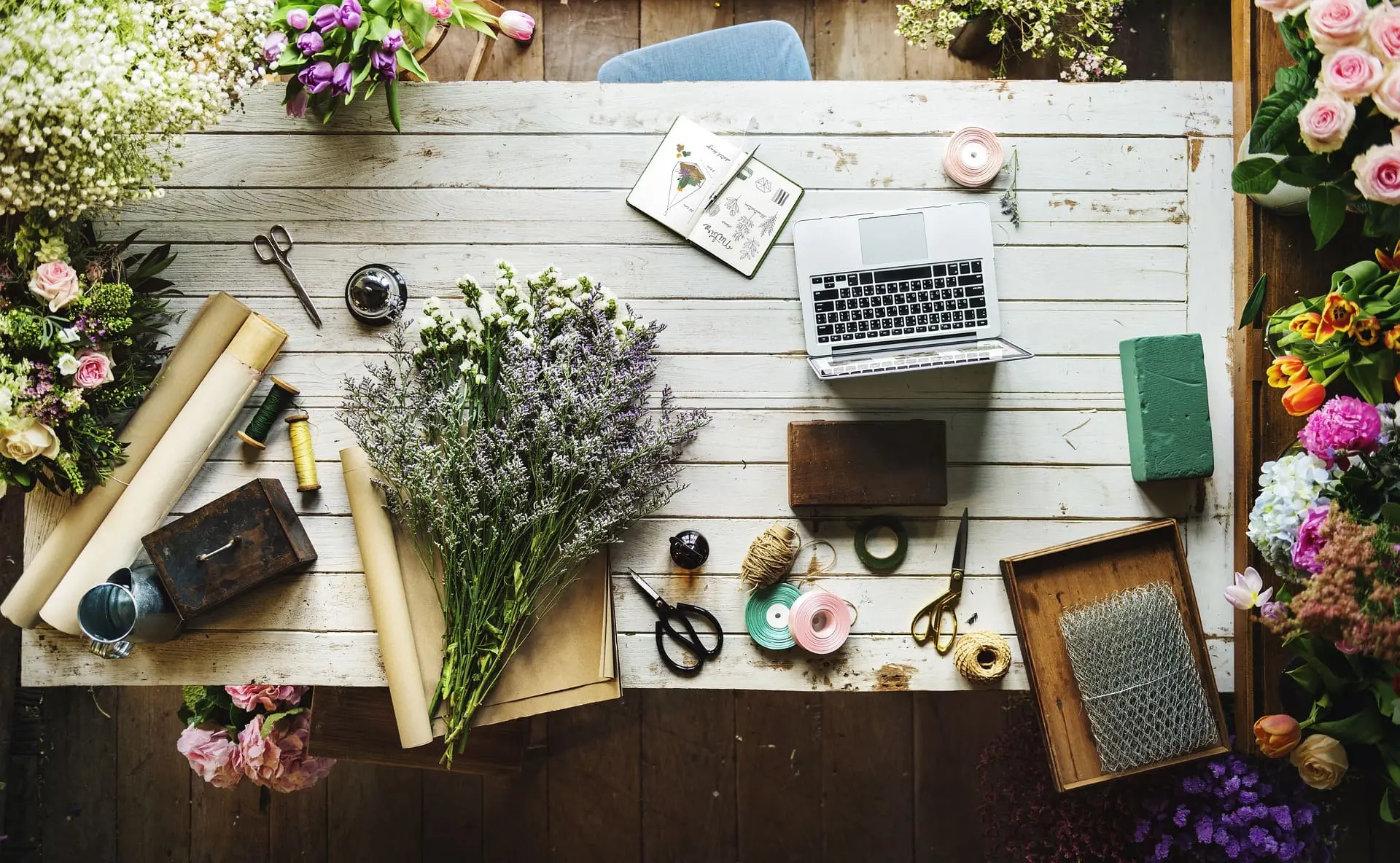 bureau avec fleurs et ordinateur.webp