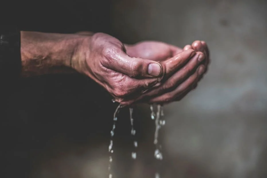 des mains qui tiennent de l'eau et qui soignent