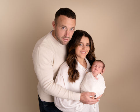 Parents holding their newborn baby in a studio family portrait in Derbyshire