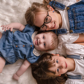 Children lying together laughing during a relaxed family photoshoot in Derbyshire