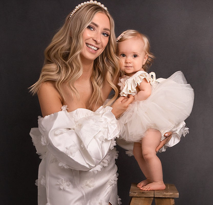 A mother and her toddler share cuddle close wearing white dresses for a photoshoot in derbyshire