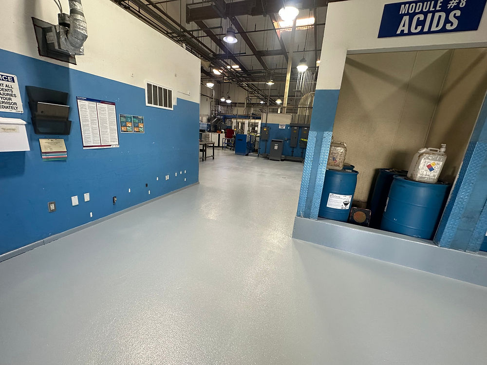 Industrial facility with blue barrels and sign 'MODULE #1 ACIDS'